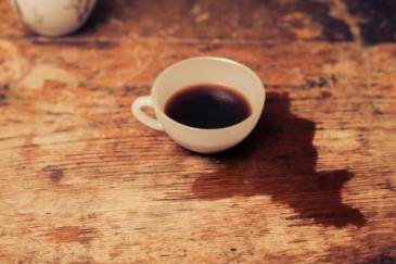 Kop koffie gemorst over houten vloer