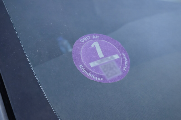Paarse Crit’Air 1 milieusticker op de voorruit van een auto in Frankrijk