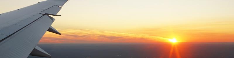 Reisverzekering Promovendum Vliegtuig zonsondergang