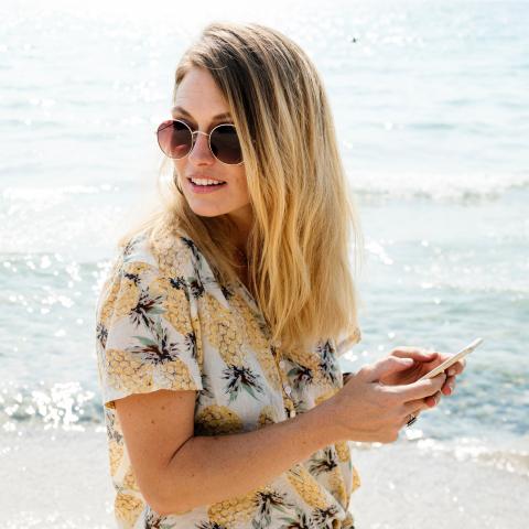 Vrouw met telefoon op strand