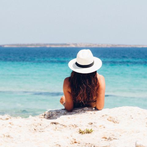 Vrouw op wit strand en blauwe zee