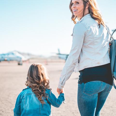moeder en dochter hand in hand op vliegveld