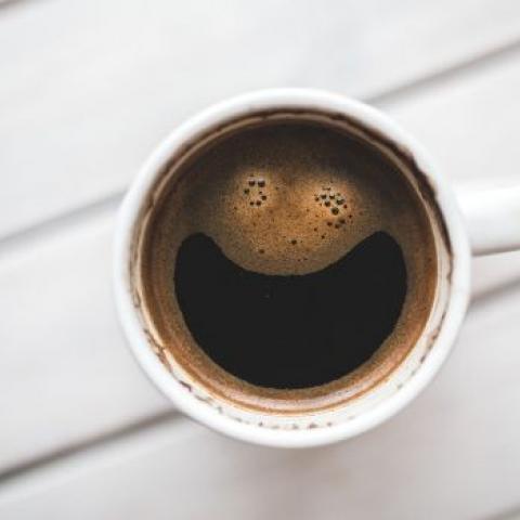 Kopje koffie met lachend gezicht