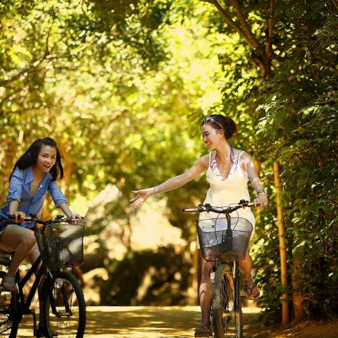 Twee fietsers, een steekt haar hand uit