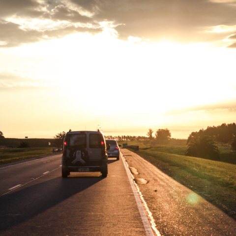 Laagstaande zon op de weg Auto's rijden op weg met laagstaande zon