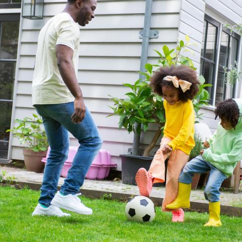 Gezin aan het voetballen in de tuin