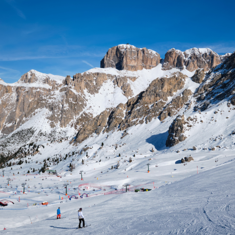 Uitzicht op een skipiste met mensen die skiën in de Dolomieten in Italië. Skigebied Belvedere. Canazei, Italië.