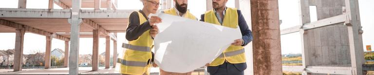 Grote verbouwing financieren Aannemers bekijken de bouwplannen van een grote verbouwing