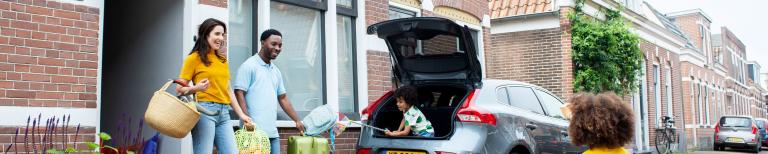 Familie laadt achterbak van auto in